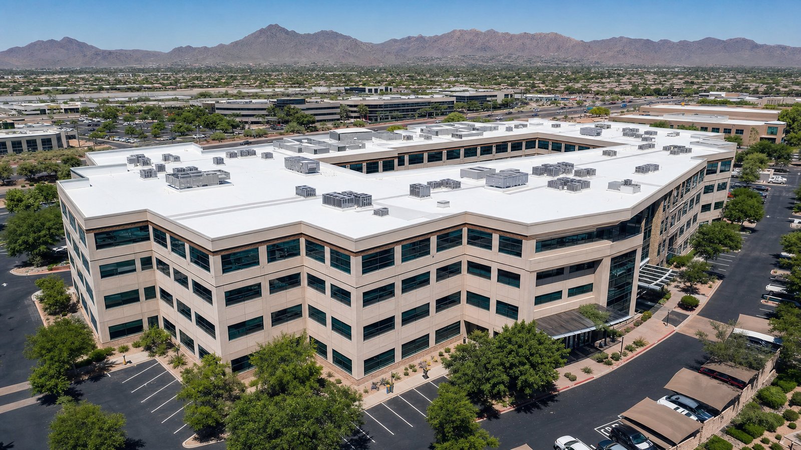 Aerial view of a Phoenix-area corporate office building with restored white foam roof