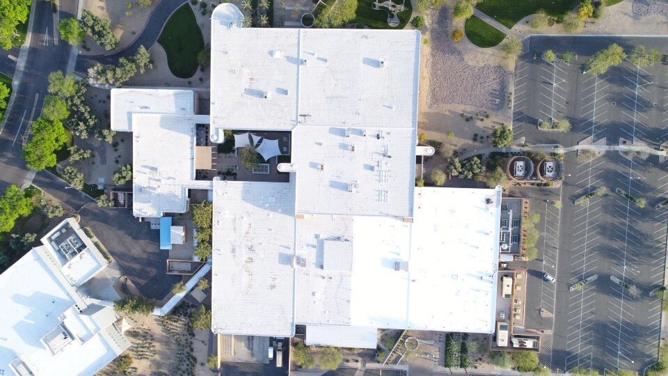 Completed ARMORCOAT AC100 foam roof recoat covering 155,000 sq ft at the AAA Insurance Arizona corporate headquarters in Glendale — orthographic drone view showing the full building footprint with bright white finished coating