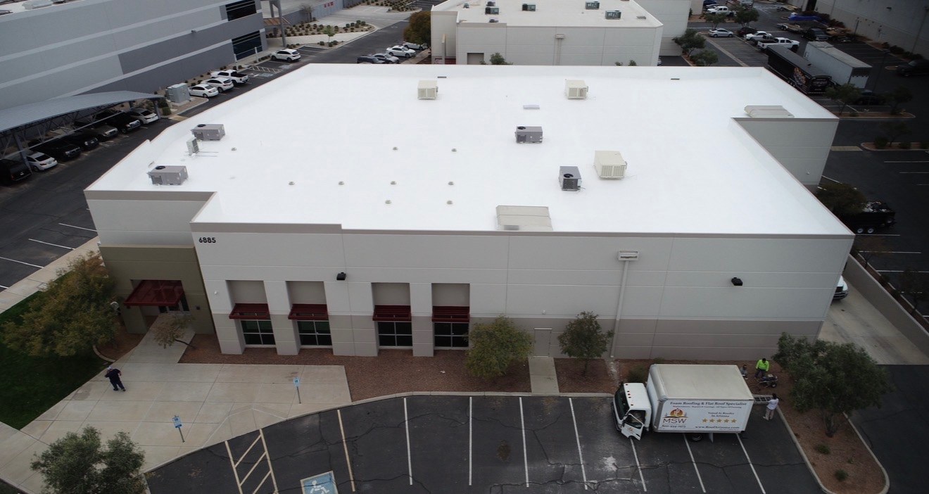 Aerial drone view of the completed 15,000 sq ft AV Dimensions industrial roof in Chandler AZ with a bright white AC100 elastomeric coating and MSW Vanguard Roofing truck on site