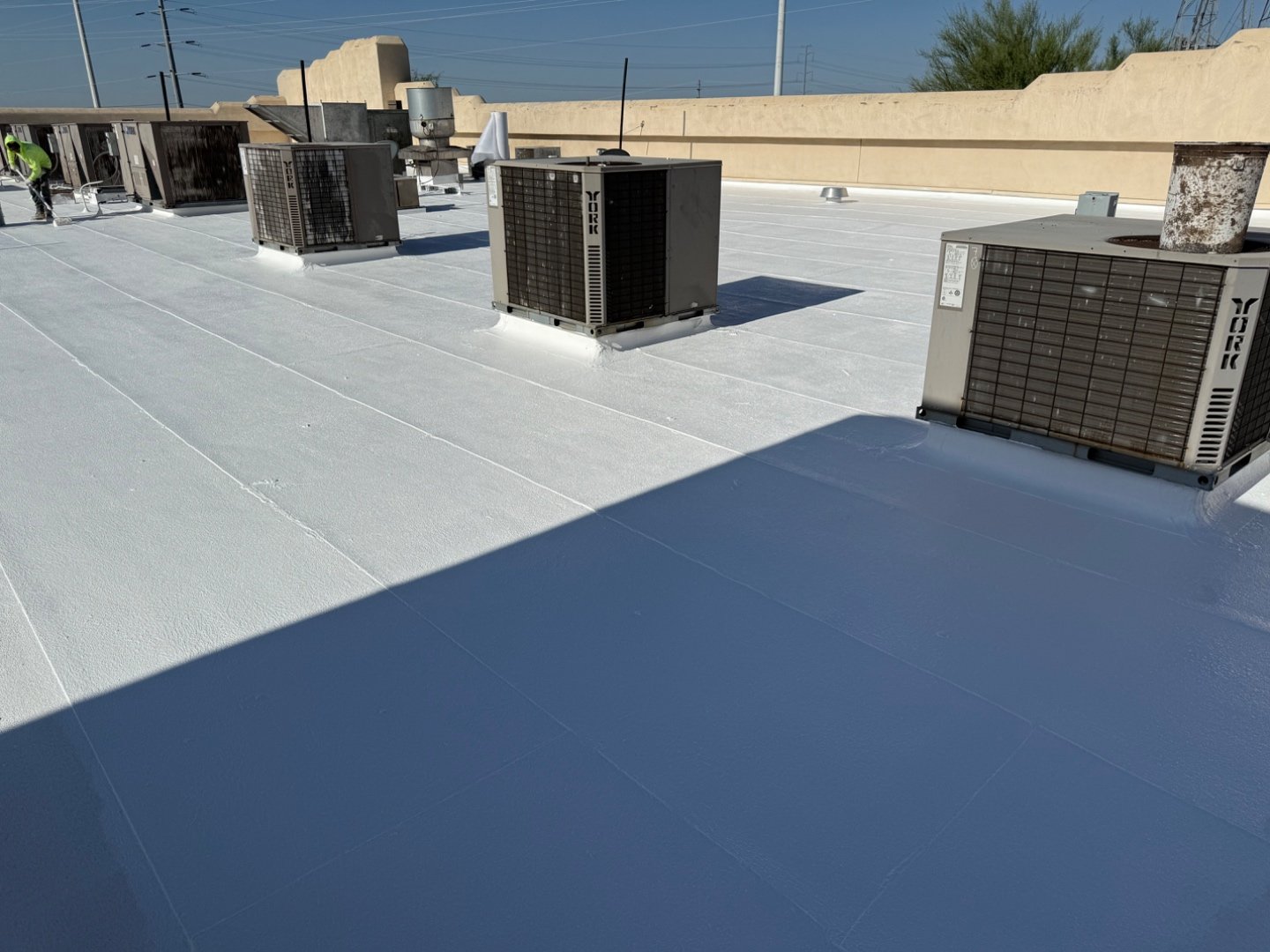 Completed bright white TRC silicone roof coating on Cold Beers Scottsdale, foam roof restoration with York HVAC condensers and grease trap exhaust, McDowell Mountains visible