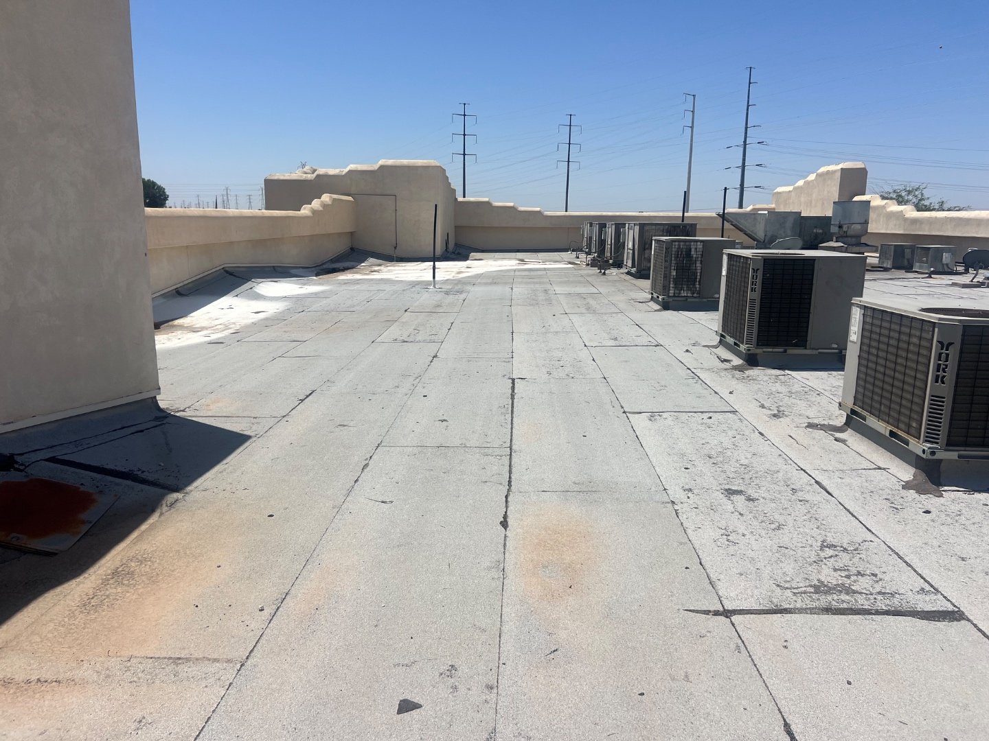 Cold Beers Scottsdale foam roof before recoat — worn coating around York HVAC condensers, kitchen exhaust penetrations, stucco parapet wall on east side