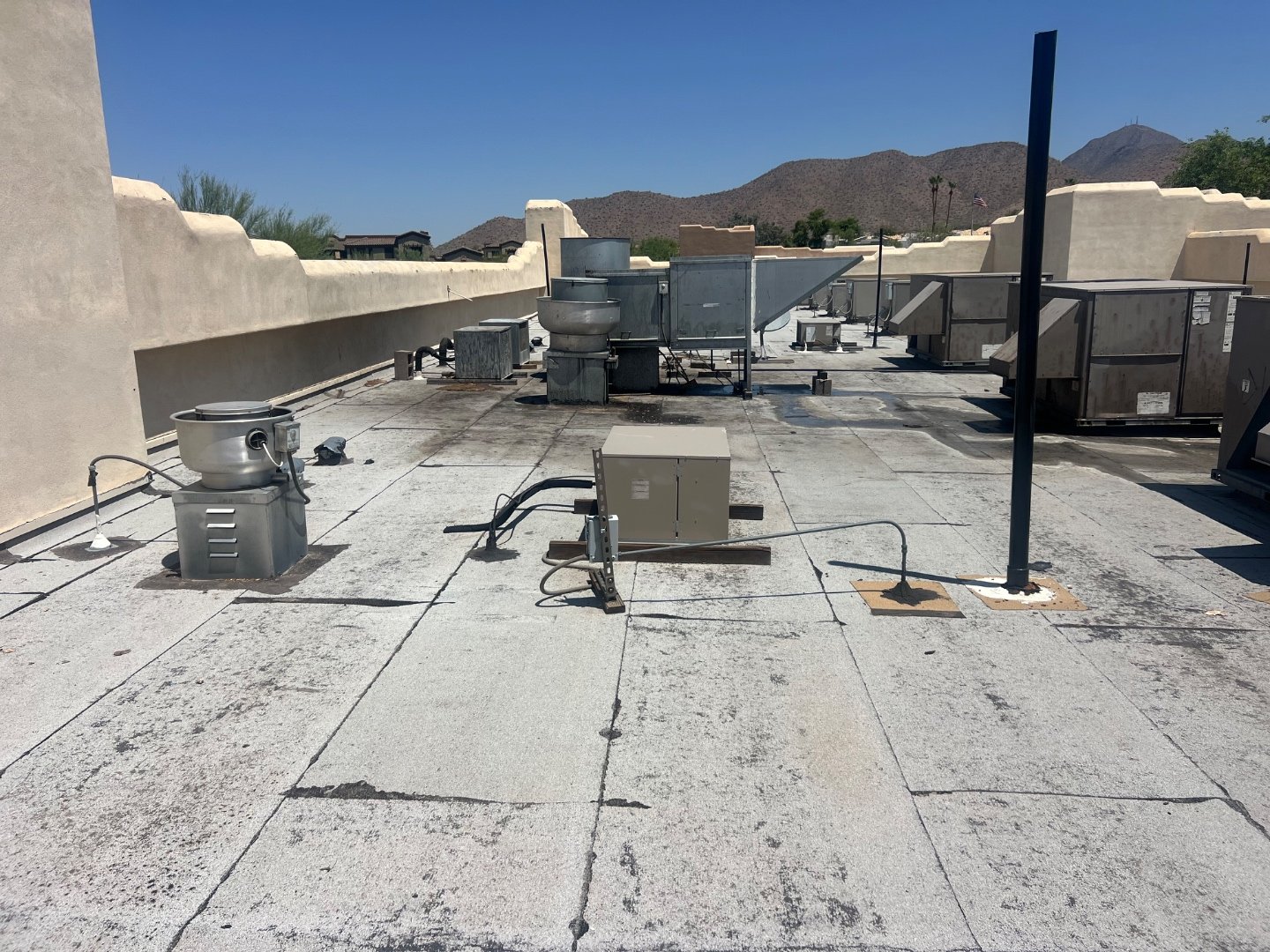 Kitchen exhaust and grease trap penetrations on worn foam roof at North Scottsdale sports bar, before ArmorPutty repair