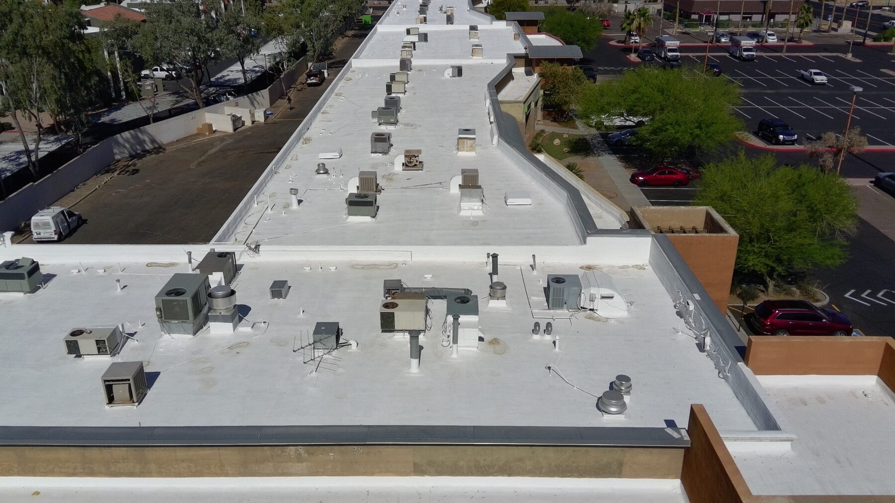 Aerial detail of the completed Glendale strip mall roof showing repaired and sealed AC units, vent stacks, and parapet transitions under the new ARMORCOAT AC100 white elastomeric coating