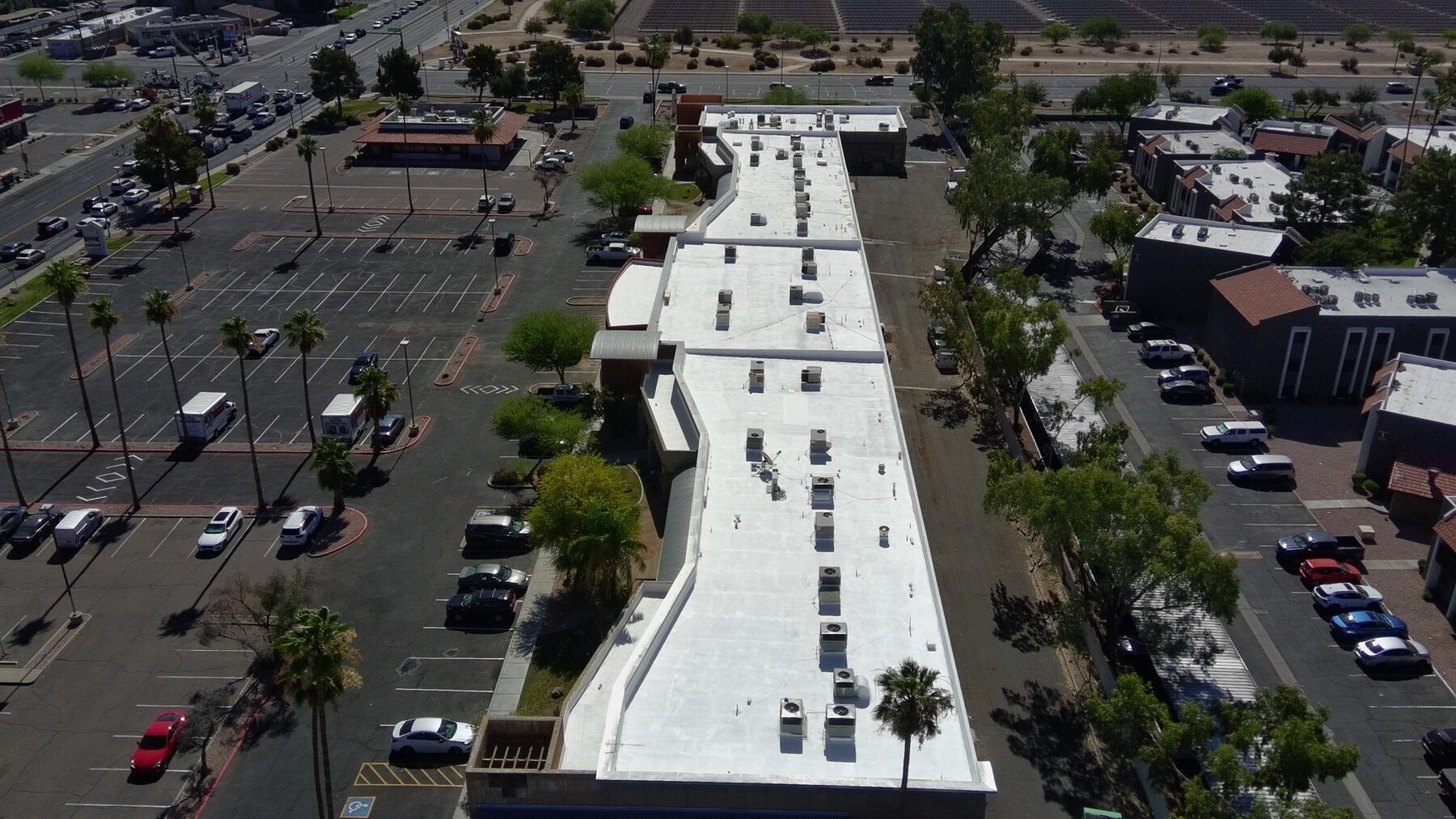 Aerial view of a restored Arizona retail center roof after foam restoration by Vanguard Roofing AZ