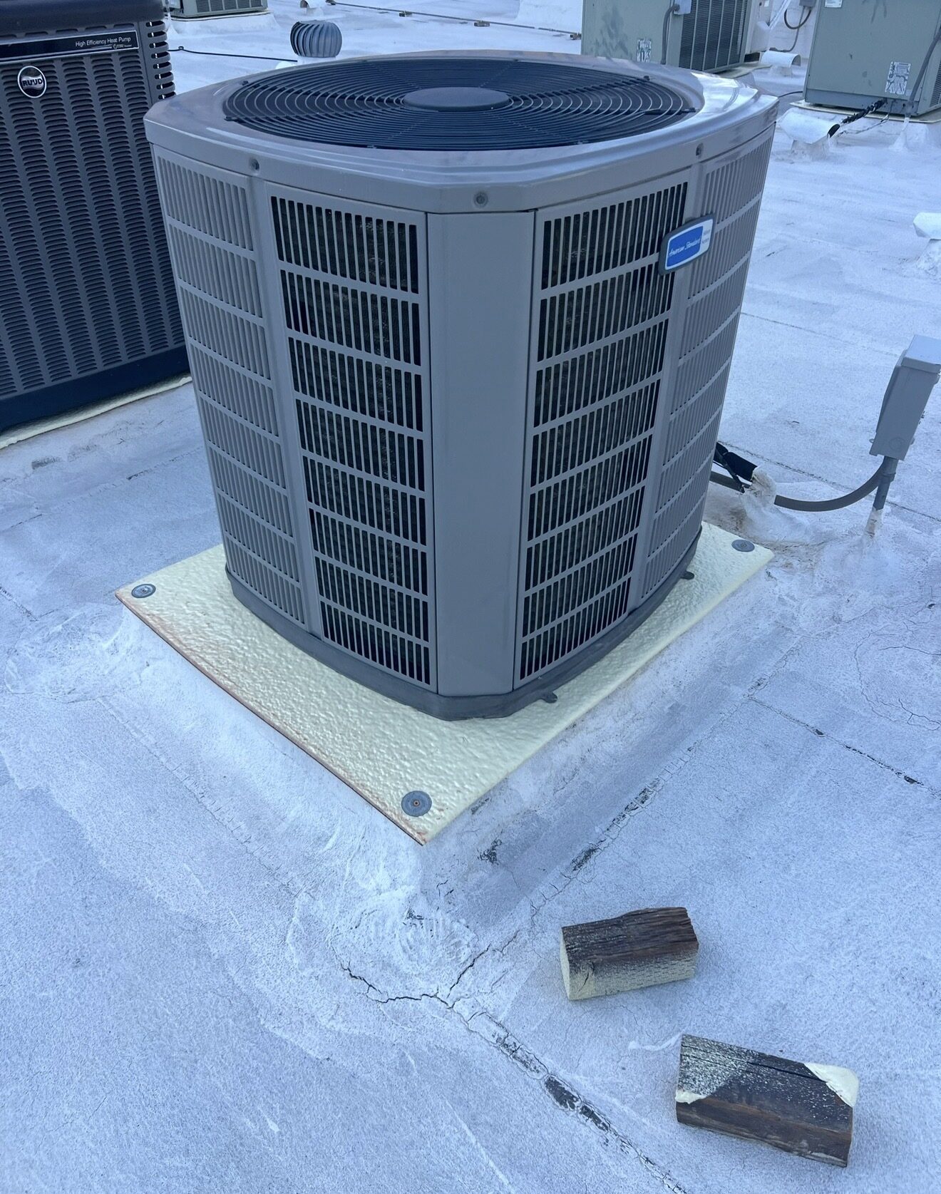 Before restoration: AC condenser unit on the Lofts on Fillmore roof in downtown Phoenix sitting on rotting wood blocks directly on the aging coated BUR roof surface with cracking visible underneath