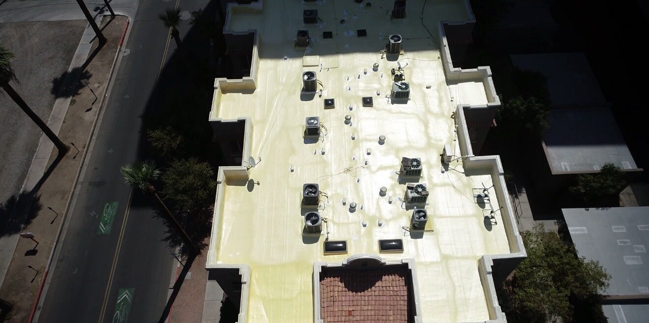 Top-down aerial drone view of the Lofts on Fillmore condo roof at 387 N. 2nd Ave in downtown Phoenix showing the freshly applied ArmorShield 2500 spray polyurethane foam over the original built-up roof substrate